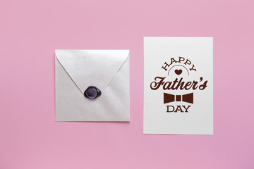 Envelope and greeting card for Father's Day on color background