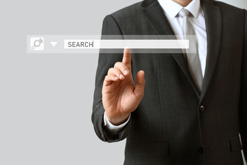 Businessman using virtual screen on light background