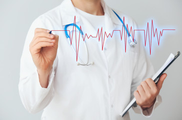 Male cardiologist drawing cardiogram against light background