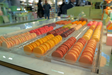 rows of multicolored macaroons in a bakery window