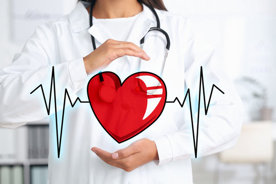 Female cardiologist with drawn heart and cardiogram in modern clinic