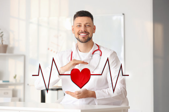 Male cardiologist with drawn heart and cardiogram in modern clinic