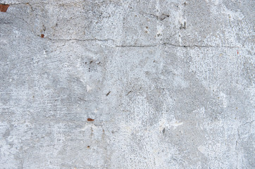 The texture of the old concrete wall with scratches, cracks, dust, crevices, roughness, stucco.