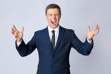 Portrait of angry businessman on grey background