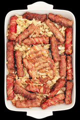 Barbecued Bacon Rolled Mixed Meat Loaves and Chicken Thighs Served with Chopped Onion in Ceramic Casserole Baking Pan Isolated on Black Background