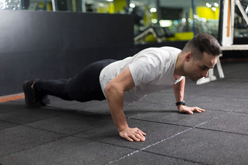 Fototapeta na wymiar Muscular young man exercising in gym.