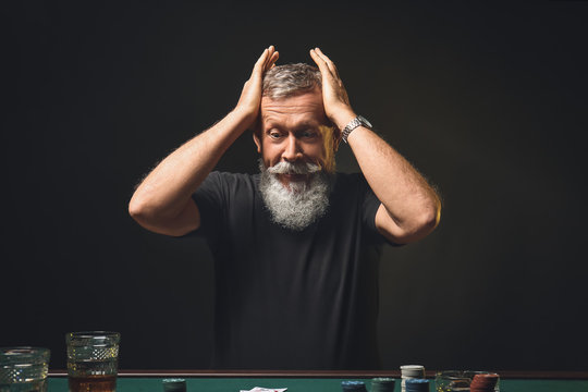 Emotional mature man after losing at poker in casino