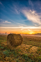 Beautiful summer sunrise over fields with hay bales © Piotr Krzeslak