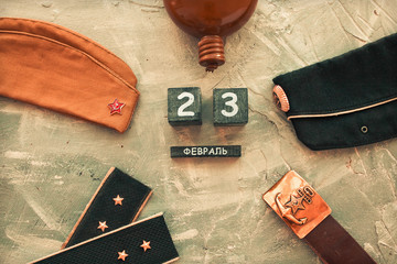 Flask, cap, soldier's military belt,shoulder straps  of the war years and a wooden calendar with the date February 23. Fatherland defender day.