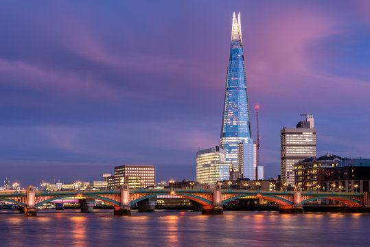 View of London city skyline on colorful sunset, with Southwark bridge over Thames river and the Shard skyscraper in the middle of the frame