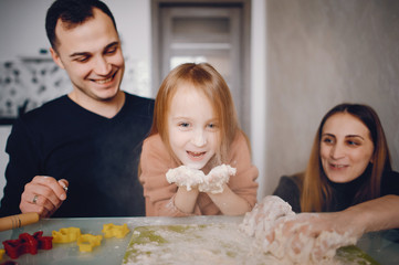 Obraz na płótnie Canvas Family in a kitchen. Little girl with a dough.