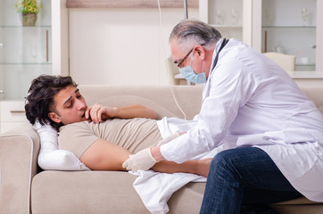 Fototapeta premium Old male doctor visiting young male patient