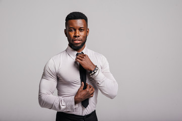 Happy confident young african american business male smiling with confidence, executive stylish company leader. Portrait of an businessman wearing suit and tie isolated on white background