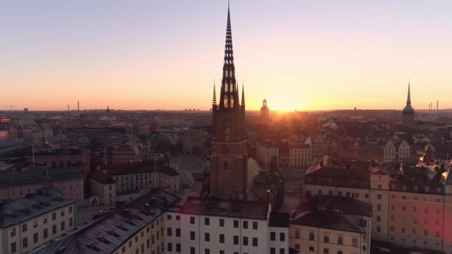 Stockholm Gamla stan City Centre at sunrise aerial view. Drone shot orbiting around church tower building on Riddarholmen island in central Stockholm. Old Town landmark, Capital of Sweden