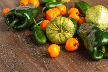 Fresh Tomatillos, Jalapeno, Habanero and Poblano Peppers on wood background