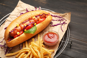 Tasty hot dog, french fries and sauce on table