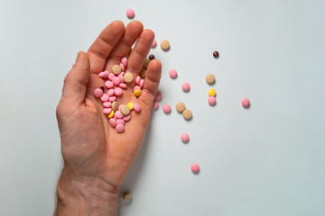 Overdose of pills, multi-colored pills in a man's hand