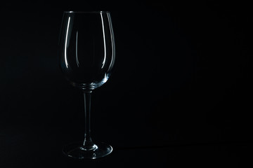 Glossy wine glass isolated on black with copy space