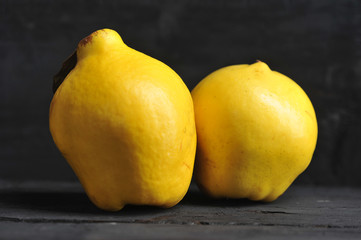 Quince fruits on a black wooden background.  Close-up.  Macro shot.