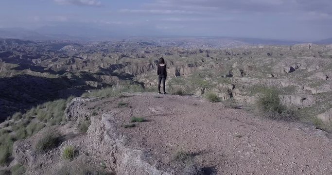 Mujer sola y libre en mirador de desierto de montañas entre la naturaleza - Drone 4K