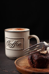 Tasty homemade muffin braking by fork. Tasty muffin with coffee close-up.