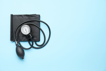 Modern sphygmomanometer on color background