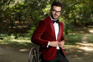 businessman wearing red tuxedo standing  and closing his coat
