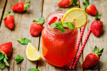 strawberry lemonade with fresh strawberries on a wood background