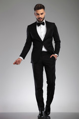 Serious young model snapping his fingers while walking