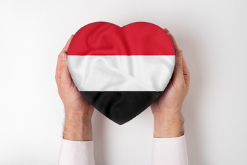 Flag of Yemen on a heart shaped box in a male hands. White background