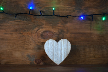 Christmas garlands with Christmas tree and heart on wooden background
