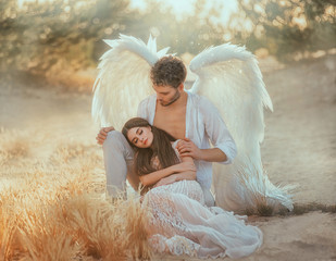 Panele Szklane  Men guardian angel protects and hugs young woman. Sleeping beauty vintage pastel color, miracle dream. Fabulous old warm yellow autumn nature. Bright sun shine light. Creative white suit design wing