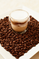 A cup of coffee in coffee beans. Coffee background