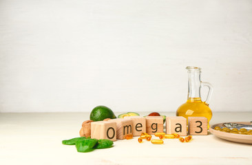 Wooden cubes, healthy products with high omega 3 and fish oil pills on white table