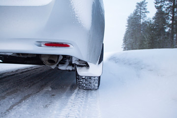Car tires on winter road covered with snow. Car on a snow covered road.