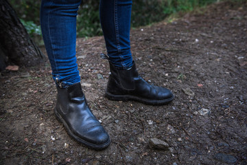 legs of a girl with boots on a forest