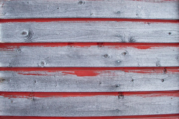 Old rustic fence with wooden texture for background in horizontal position and lines of red paint.