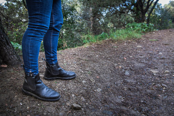 legs of a girl with boots on a forest