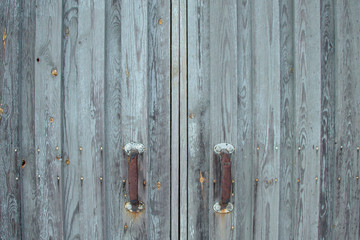 Old wooden gates with rusty handles.