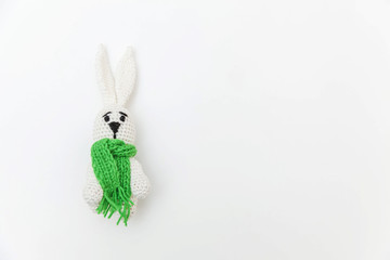 Simply minimal design with toy bunny in green scarf isolated on white background. Children care materinity family concept. Flat lay, top view, copy space