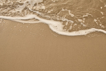Sea water caressing the orange sand