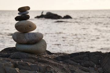 Fototapeta na wymiar Formation stones zen style, in the background on a rock in the sea a bird