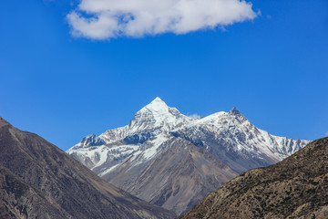 Nepal snowy mountains against the blue sky with clouds