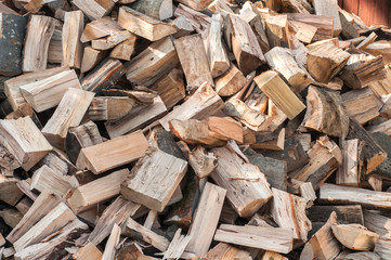 Cut chopped pile of firewood closeup as wooden background