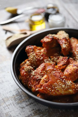 Selective focus. Appetizing buffalo wings in a pan. Baked chicken wings with sesame seeds.