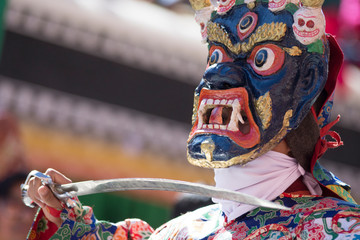Creature dancing with a sword in Gustor mask festival in Ladakh, India