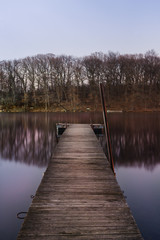 A dock on a calm pond in beautiful magenta night light