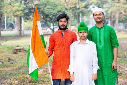 Three kids and young boys of different age and different religion hearing tricolor dress and holding Indian National flag. Indian kids celebrating Republic or Independence day of India.  - Powered by Adobe