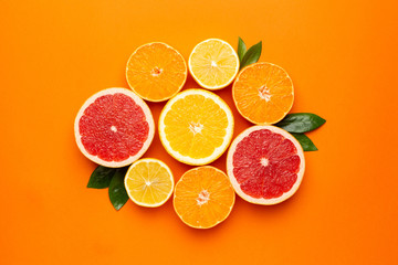 Citruses fruits on orange background, fruit flatlay, summer minimal compositon with grapefruit, lemon, mandarin and orange. Summer color , harvest, cutting fruits