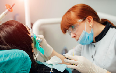 Fototapeta premium Female dentist is working in modern stomatology clinic. Stomatological instrument in the dentist clinic. Medicine, health, stomatology concept.